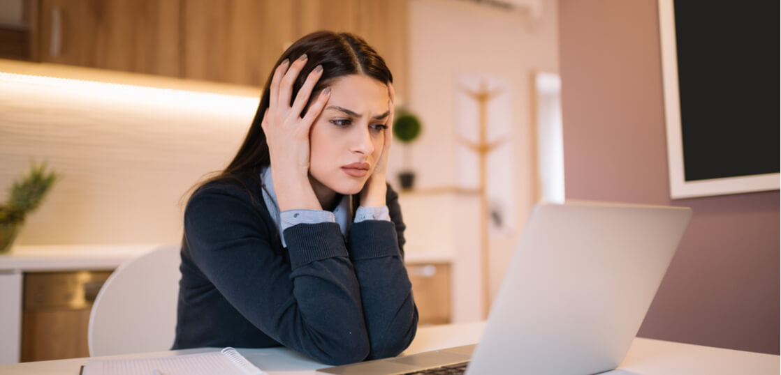 Frustrated_worried_young_woman_looks_at_laptop
